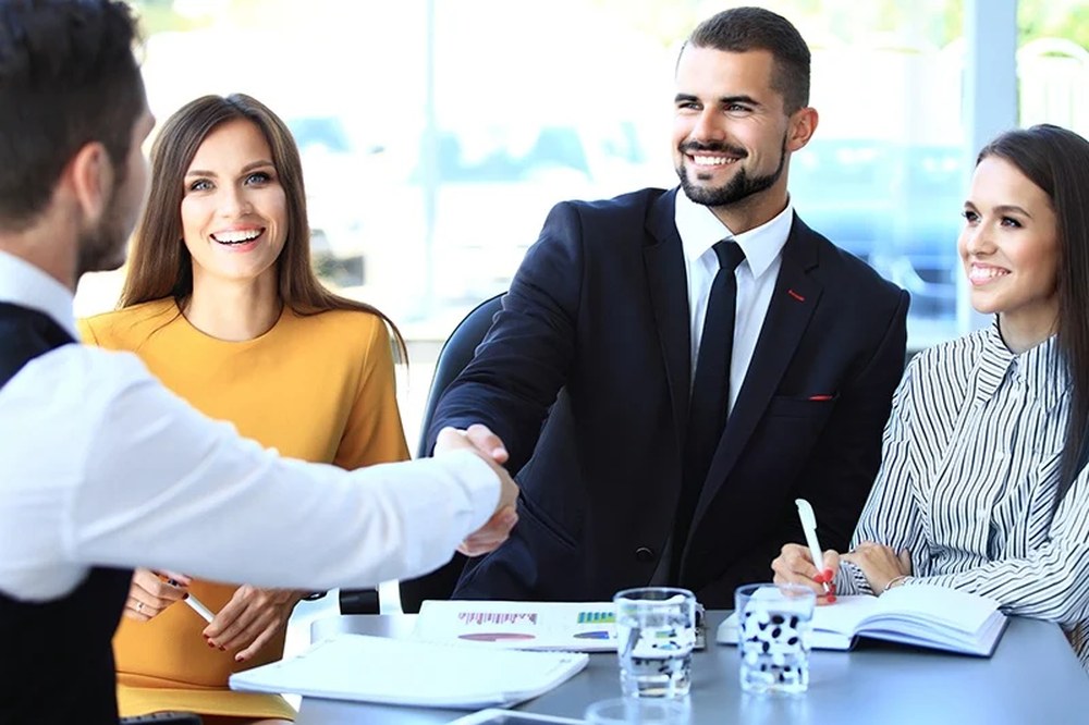 A recruitment consultant shaking hands with a candidate after a successful interview